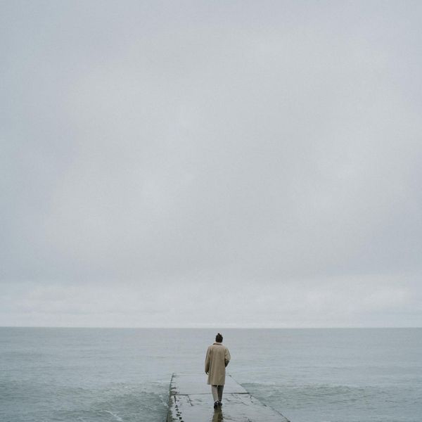 Person meditating peacefully in a minimalist environment.