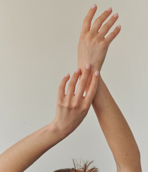 Woman in a calm pose surrounded by gentle light.